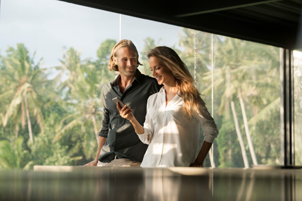 Smiling couple with smartphone in design house